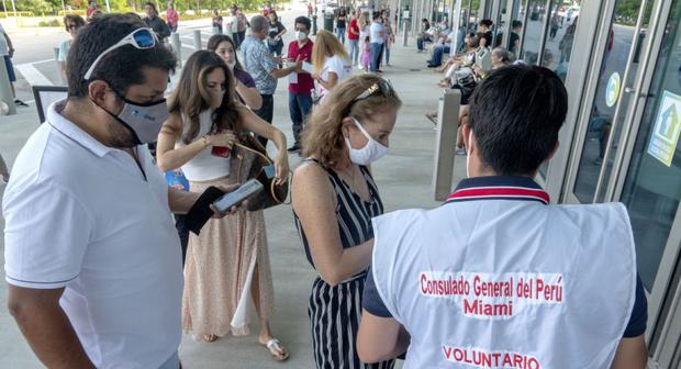 Un voluntario ayuda a ciudadanos peruanos residentes en Estados Unidos a su llegada a un colegio electoral en el Centro de Convenciones de Miami Beach. (EFE / EPA / CRISTOBAL HERRERA-ULASHKEVICH).

