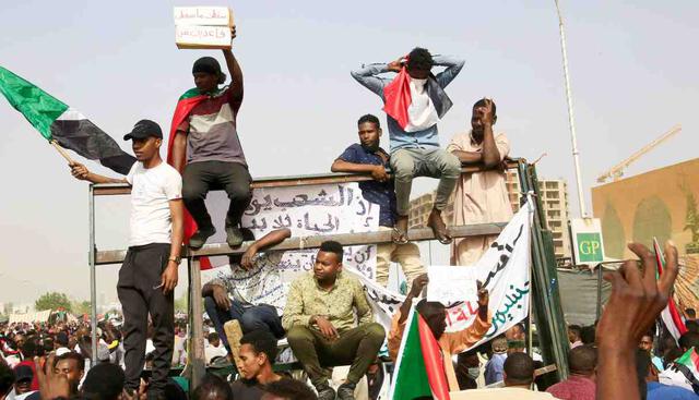 Varios activistas celebran mientras se dirigen al cuartel general del Ejército sudanés para pedir la salida del presidente, Omar al Bashir, este jueves, en Jartum. (Foto: EFE)