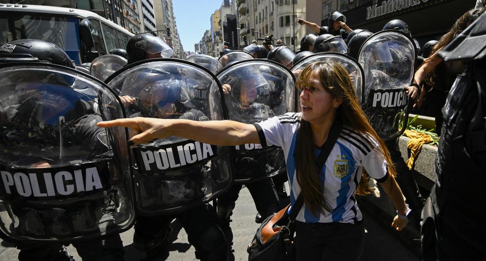 La policía antidisturbios choca con manifestantes después de una protesta convocada por la Confederación General del Trabajo (CGT) de Argentina contra el decreto de emergencia del presidente Javier Milei. (Foto de Luis ROBAYO/AFP).
