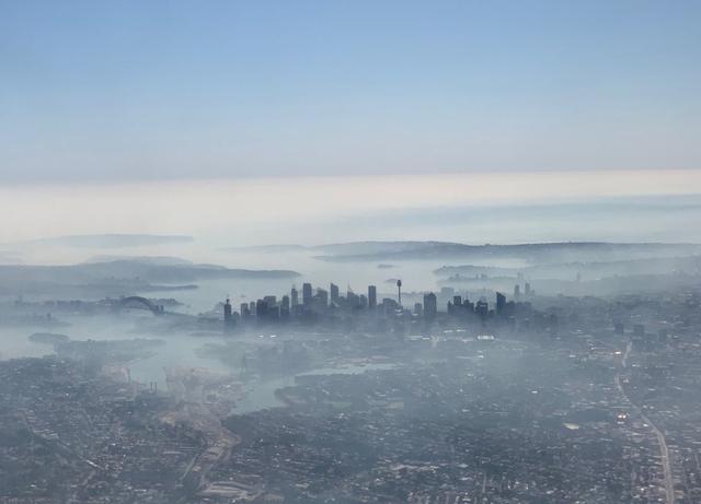 Una imagen tomada en un teléfono inteligente desde la ventana de un avión muestra neblina de humo cubriendo Sydney, Australia. (Reuters)