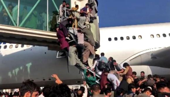 Civiles afganos intentan desesperadamente subir a un avión en el aeropuerto de Kabul.