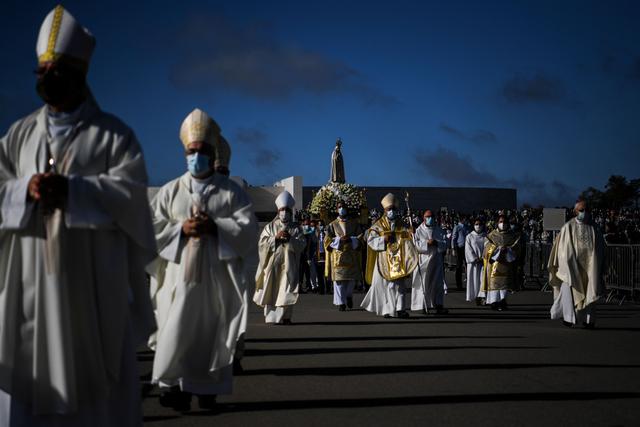 Se lleva una estatua de Nuestra Señora de Fátima durante una ceremonia en el centro de Portugal. Los ciudadanos utilizaron mascarillas por el coronavirus y guardaron su respectiva distancia. (AFP / PATRICIA DE MELO MOREIRA).