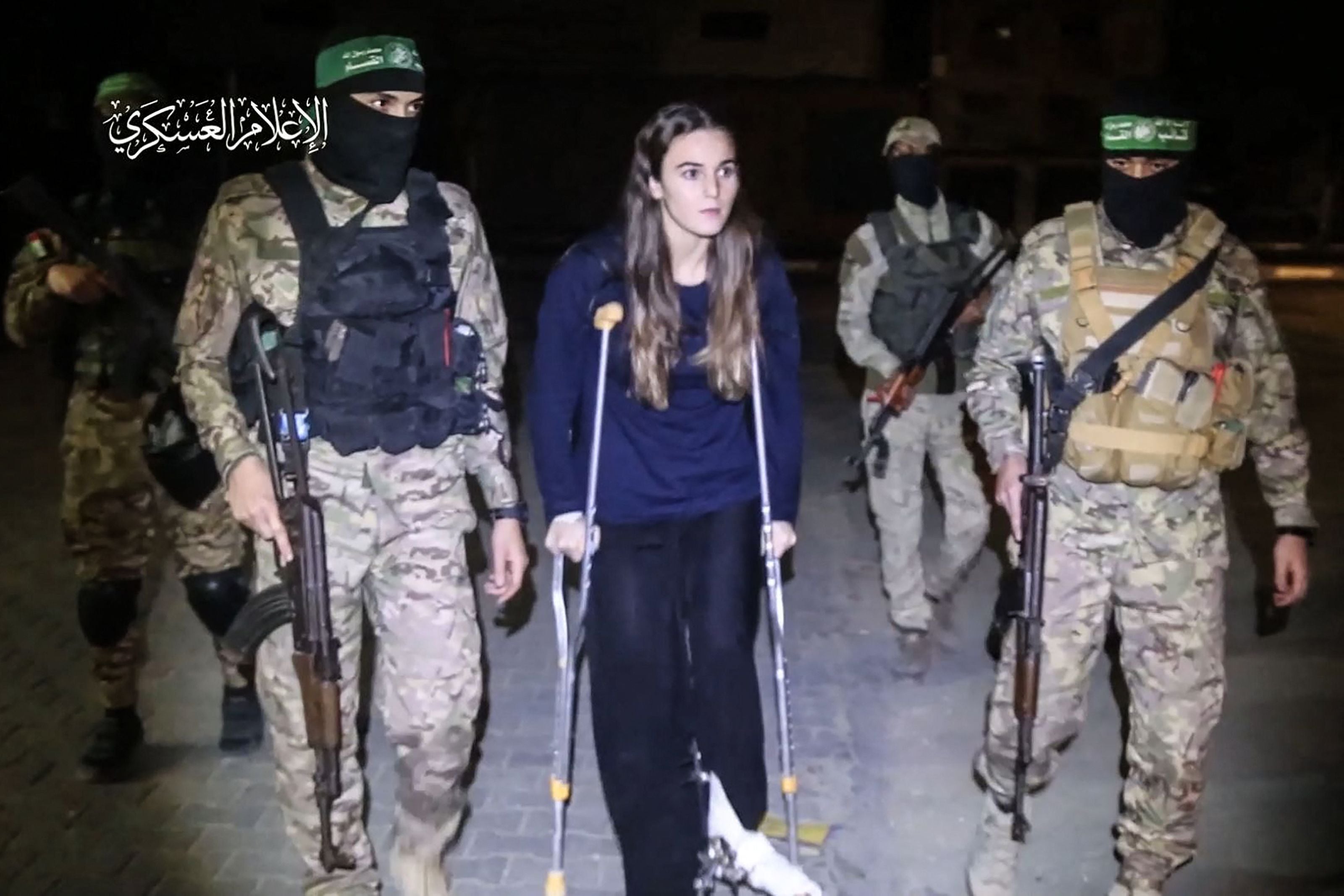 Hamas fighters escort recently released Israeli hostage Maya Regev, 21, to a Red Cross vehicle in the Gaza Strip early on November 26, 2023. (AFP).
