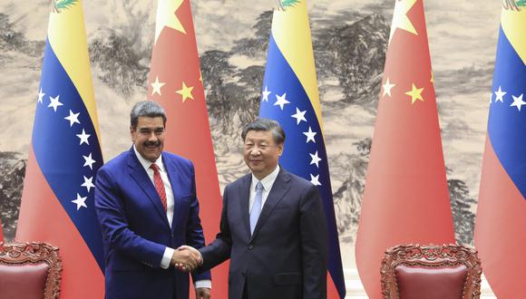 El presidente chino, Xi Jinping (derecha), le da la mano al presidente venezolano, Nicolás Maduro. (Foto de ZURIMAR CAMPOS/venezolana Presidencia / AFP)