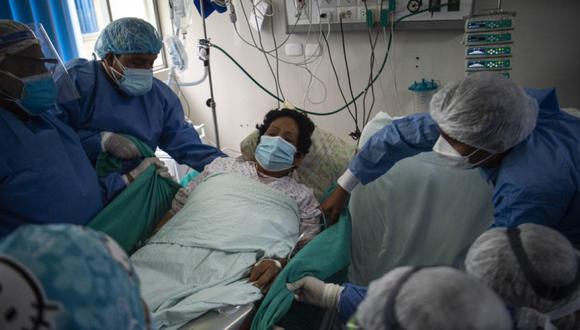 Profesionales de la salud asisten a la paciente de COVID-19 Aquilia Huamani, de 63 años, en la Unidad de Cuidados Intensivos del Hospital Alberto Sabogal Sologuren, en Lima. (Foto: Ernesto BENAVIDES / AFP)