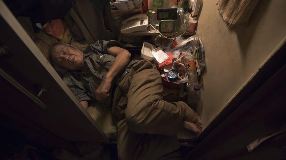 Cheung Chi-fong de 80 a&ntilde;os duerme en un peque&ntilde;o cub&iacute;culo en el que no alcanza a estirar sus piernas. Cerca de 200 mil personas viven en estas condiciones en Hong Kong, seg&uacute;n el gobierno local. (AP Photo/Kin Cheung). (AP)