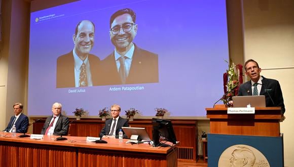 Thomas Perlmann, secretario del Comité Nobel, junto a una pantalla que muestra a los ganadores del Premio Nobel de Fisiología o Medicina 2021 David Julius y Ardem Patapoutian, durante una conferencia de prensa en el Instituto Karolinska de Estocolmo. (Foto: Jonathan NACKSTRAND / AFP)