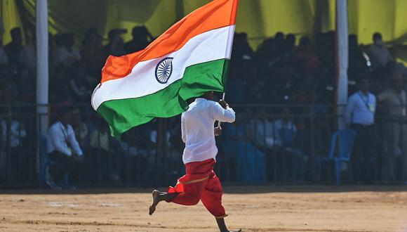 Un estudiante de escuela corre con una bandera de la India durante las celebraciones del 74º Día de la República de la India en Bengaluru el 26 de enero de 2023. (Foto referencial de Manjunath KIRAN / AFP)