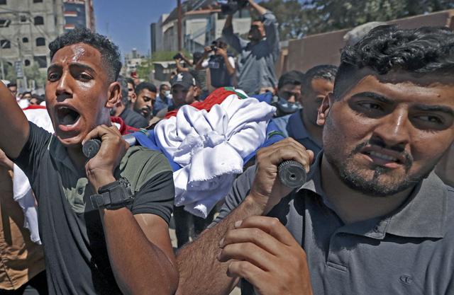 Los deudos palestinos llevan el cuerpo de un miembro de la familia Abu Hatab durante una procesión fúnebre en la ciudad de Gaza. Diez miembros de la familia murieron en un ataque aéreo israelí en el oeste de la Franja de Gaza. (Foto de MAHMUD HAMS / AFP).