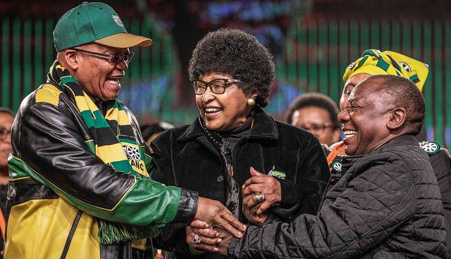 (FILES) In this file photo taken on June 30, 2017 former wife of the late South African President Nelson Mandela, Winnie Mandela (C) holds the hands of South African President Jacob Zuma (L) and South African Deputy President Cyril Ramaphosa (R) during the opening session of the South African ruling party African National Congress policy conference in Johannesburg.  Winnie Mandela, the ex-wife of South African anti-apartheid fighter and former president Nelson Mandela, died on April 2, 2018 in a Johannesburg hospital after a long illness at the age of 81, her spokesman Victor Dlamini said in a statement. / AFP / GIANLUIGI GUERCIA