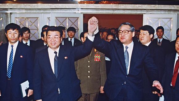 El primer ministro surcoreano, Chong Won-Shik (D), y su homólogo norcoreano, Yon Hyong-Muk (I), se dan la mano tras firmar un pacto de reconciliación entre sus respectivos países, el 13 de diciembre de 1991, en Seúl. (Foto de KIM JAE-HWAN / AFP)