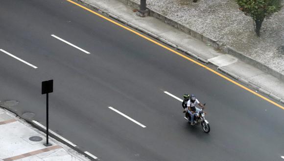 Una pareja transita en una motocicleta en Guayaquil al término del toque de queda entre las 23.00 y las 05.00 decretado por el gobierno del presidente de Ecuador Daniel Noboa. (EFE/ Carlos Durán Araújo).