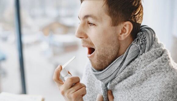 Un hombre aplicándose un spray para el dolor de garganta. | Imagen referencial: 
Gustavo Fring / Pexels