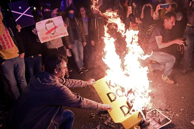 Los manifestantes independentistas queman fotos y carteles contra la monarquía española durante una protesta llamada "ni Rey ni miedo" contra la visita de la familia real española en Barcelona. (Foto: AFP)