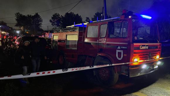 Un camión de bomberos estacionado cerca del lugar donde un incendio arrasó un asentamiento habitacional matando a 14 migrantes venezolanos, entre ellos ocho niños, en el campamento Los Pirquenes, en la comuna de Coronel, Región del Bío Bío, Chile. (Foto de Ivan FLORES/AFP).