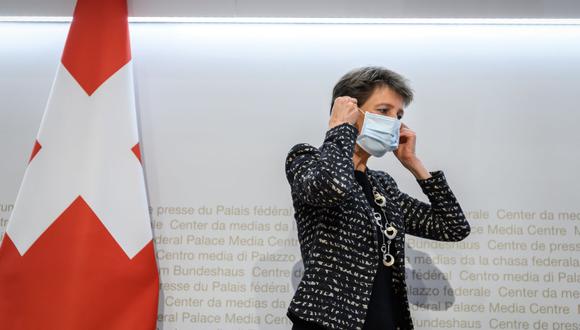La presidenta de Suiza Simonetta Sommaruga se pone una mascarilla protectora después de una conferencia de prensa anunciando nuevas medidas contra el coronavirus. (Foto de Fabrice COFFRINI / AFP).