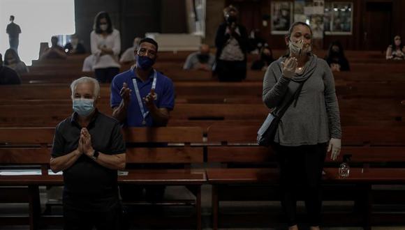 Personas son vistas con tapabocas en una iglesia durante la celebración de una eucaristía en Río de Janeiro, Brasil, en plena pandemia de coronavirus. (EFE/Antonio Lacerda/Archivo).