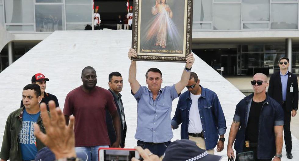El presidente brasileño, Jair Bolsonaro, plantea una imagen de Jesucristo durante una reunión con partidarios católicos y antiabortistas frente al Palacio de Planalto en Brasilia. (AFP/Sergio Lima)