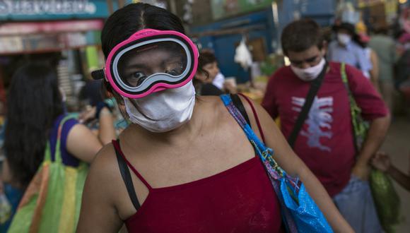 Una mujer usa una máscara de buceo y una máscara quirúrgica como medida de precaución contra la propagación del nuevo coronavirus. (AP Photo/Rodrigo Abd)