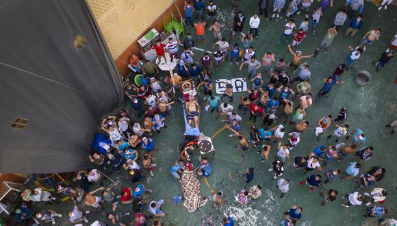 Los reclusos se reúnen alrededor de los cadáveres de dos reclusos durante un motín en la prisión de Miguel Castro Castro, en Lima, Perú. (Foto AP / Rodrigo Abd).