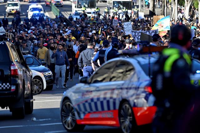 La policía bloquea el camino a los manifestantes durante una manifestación cuarentena en Sydney, mientras miles de personas se reunieron para manifestarse contra las órdenes de la ciudad de quedarse en casa durante un mes. (Foto de Steven SAPHORE / AFP)