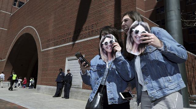 Dos personas con la imagen de la actriz Lori Loughlin en el exterior de la corte federal de Boston este miércoles 3 de abril. (Foto: AP)