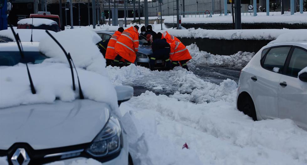 El personal de ayuda intenta sacar un automóvil de la nieve en la carretera de circunvalación más grande de Atenas, la capital de Grecia, el 25 de enero de 2022.  (EFE/EPA/YIANNIS KOLESIDIS).