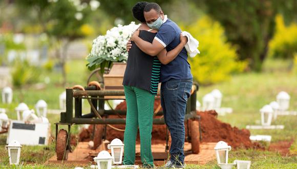 Dos personas asisten al entierro de un ser querido víctima del coronavirus covid-19 en Brasil. (EFE/Joédson Alves/Archivo).