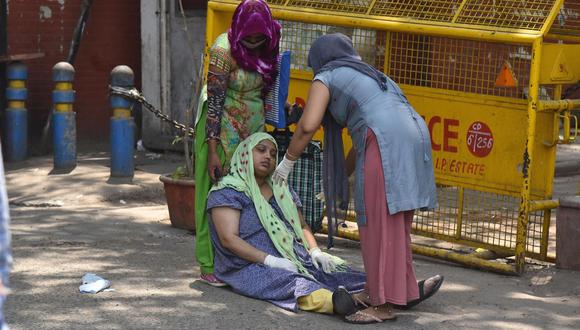 Una mujer sospechosa de tener coronavirus covid-19 espera tratamiento afuera de un hospital en Nueva Delhi, India, 27 de abril de 2021. (EFE / EPA / IDREES MOHAMMED).
