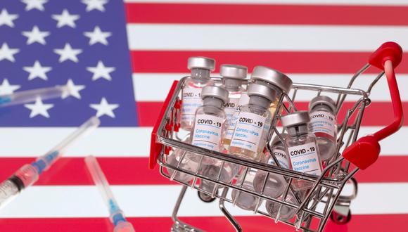 Una pequeña canasta de compras llena de viales con la etiqueta "COVID-19 - Vacuna contra el coronavirus" y jeringas médicas se colocan en una bandera de Estados Unidos. Fotografía tomada el 29 de noviembre de 2020. (REUTERS/Dado Ruvic).