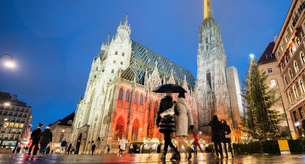 La gente pasa por el mercado navideño de Viena, que está cerrado, y por la catedral de San Esteban en Viena, Austria, el 22 de noviembre de 2021, durante el confinamiento por la pandemia del coronavirus. (GEORG HOCHMUTH / APA / AFP).
