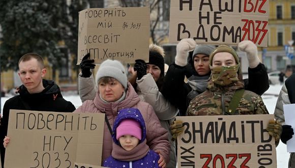 Familiares y hermanos de armas de prisioneros de guerra ucranianos de la Brigada Azov sostienen pancartas en la manifestación en Kiev el 21 de enero de 2024, pidiendo su intercambio con prisioneros rusos, en medio de la invasión rusa en Ucrania. (Foto de Sergei SUPINSKY / AFP)