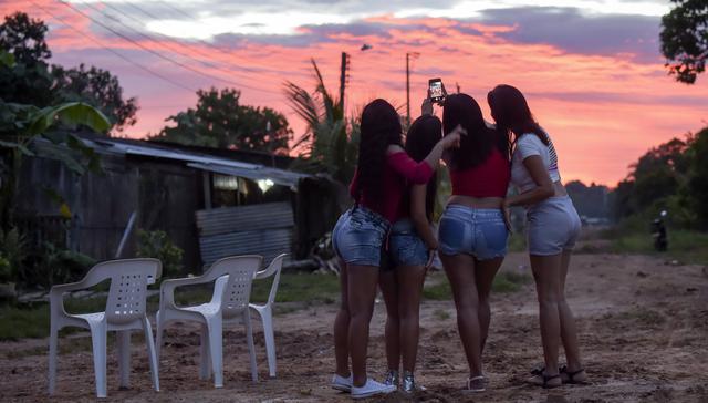 Un grupo de venezolanas que trabajan en un burdel en la localidad colombiana de Calamar se toman un selfie. Las mujeres aseguran que se prostituyen para enviar dinero a sus familias en Venezuela. (AFP).