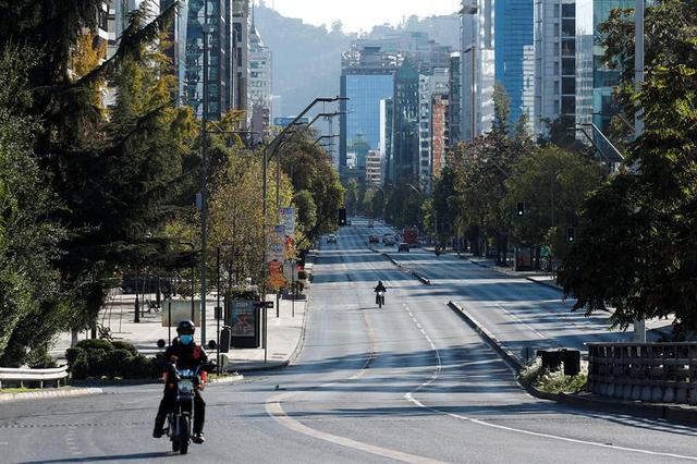 Dos motociclistas transitan por una avenida casi vacía durante la cuarentena obligatoria decretada en prácticamente todo Chile ante el avance de la pandemia de coronavirus covid-19. (Foto: EFE/Alberto Valdés).