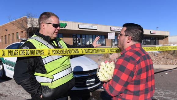 Un oficial del Servicio Comunitario de Colorado Springs habla con Jace Khosla, de Pueblo, la mañana después de un tiroteo masivo en el Club Q. (JASON CONNOLLY / AFP).
