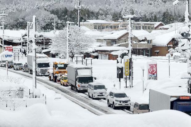 Traffic moves slowly as snow covers the roads in the city of Hikone.
