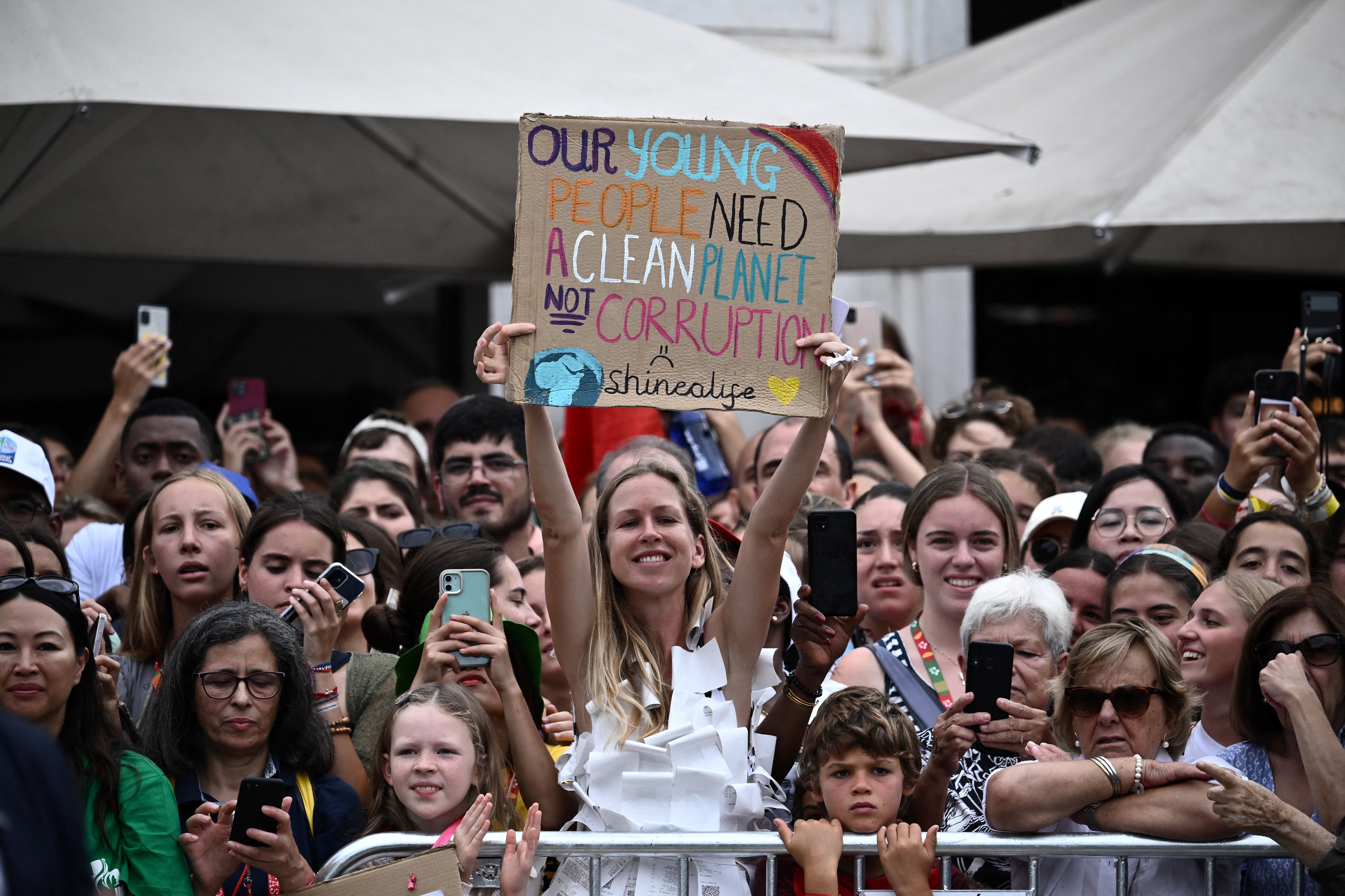 A woman holds a sign that says 
