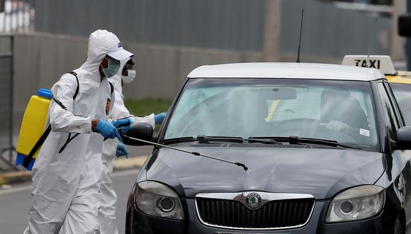 Trabajadores desinfectan un vehículo como parte de las medidas para contener la propagación del coronavirus en Ecuador. (EFE/ Jose Jacome).
