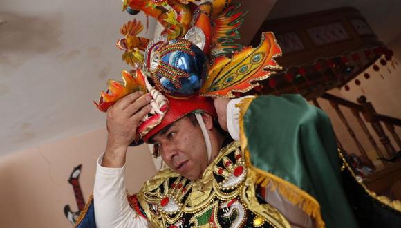 Julio Rodríguez se pone su traje de "Diablada" o Danza de los Diablos para realizar el baile tradicional como homenaje al carnaval, en Oruro, Bolivia. (Foto: AP/Juan Karita)