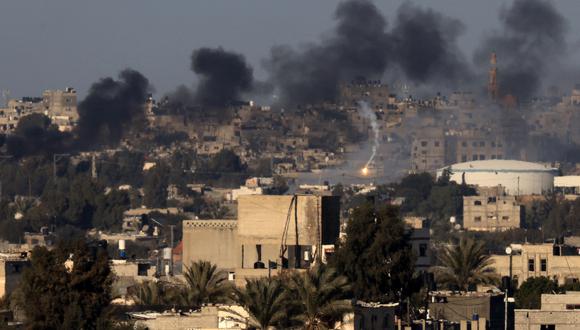 Esta fotografía tomada el 15 de enero de 2024 desde Rafah muestra una bengala y humo ondeando sobre Khan Yunis en el sur de la Franja de Gaza durante el bombardeo israelí, en medio de batallas en curso entre Israel y el grupo militante palestino Hamás. (Foto de AFP)