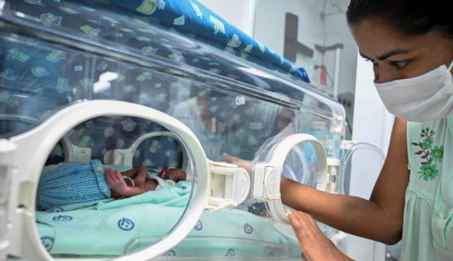 Diana Paola Angola, quien se recuperó del nuevo coronavirus, acaricia a su hijo Jefferson en la sala neonatal de la Clínica Versalles de Cali (Colombia). (AFP / Luis ROBAYO).