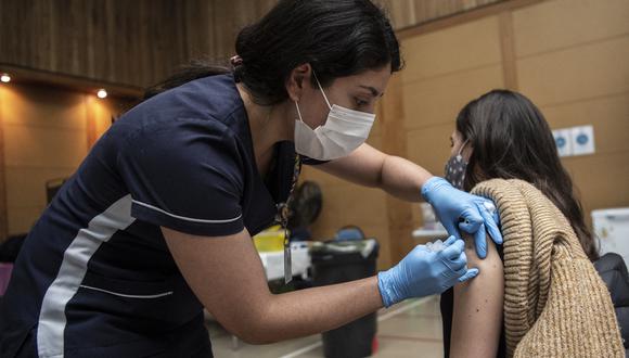 Un trabajador de salud administra una dosis de la vacuna Pfizer-BioNTech contra COVID-19 a un menor en un centro de vacunación en Santiago. (Foto: MARTIN BERNETTI / AFP)