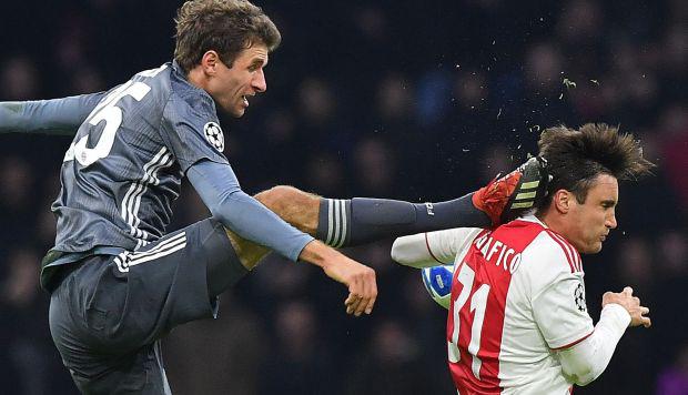 Nicolás Tagliafico recibiendo la patada de Müller. (Foto: AFP)