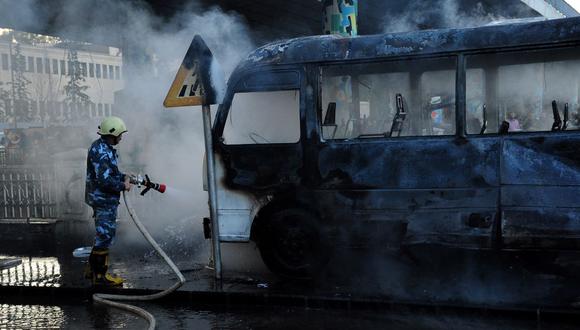 Un autobús del ejército sirio quemado tras ser atacado con artefactos explosivos en la capital de Siria, Damasco, el 20 de octubre de 2021. (SANA / AFP).