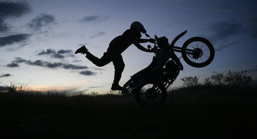 Pedro Aldana hace una "wheelie" en su moto durante una presentación en el barrio Ojo de Agua de Caracas. (Foto: AP/Matias Delacroix)