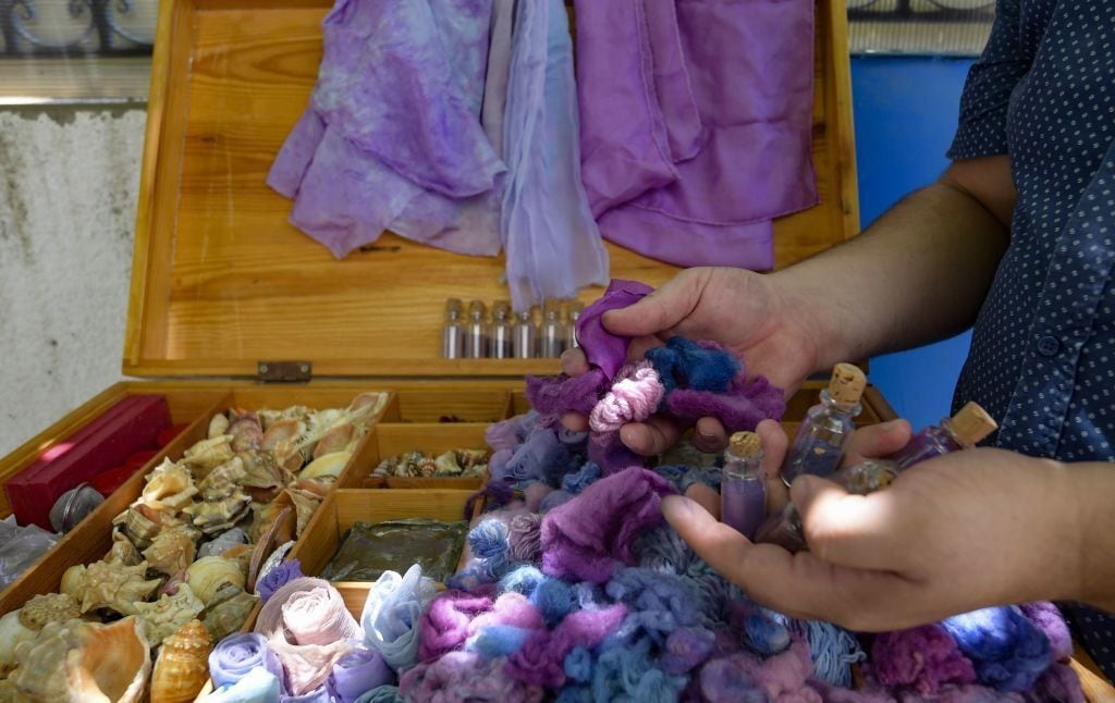 Threads and fabrics dyed in the purple color extracted from snails by the Tunisian artisan Mohamed Ghassen Nouira, who in 2020 set out to revive the trade.  (GETTY IMAGES).