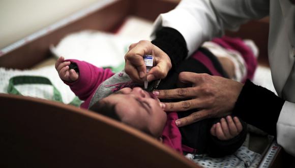 Un médico palestino aplica fármaco a un bebé en el establecimiento de la UNRWA en Gaza. (Foto: AP/Khalil Hamra)