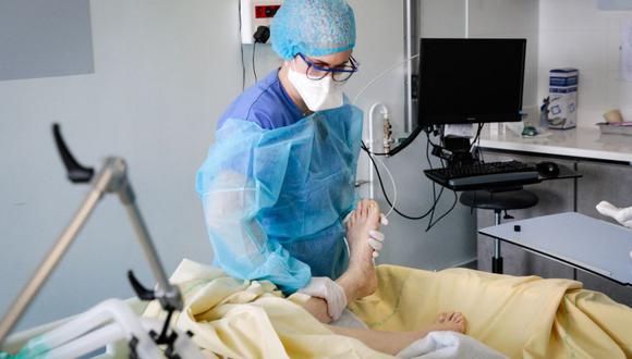 Una enfermera atiende a un paciente de coronavirus en la unidad de cuidados intensivos del hospital Antoine Beclere AP-HP en Clamart, en las afueras de París, Francia, el 23 de diciembre de 2021. (GEOFFROY VAN DER HASSELT / AFP).