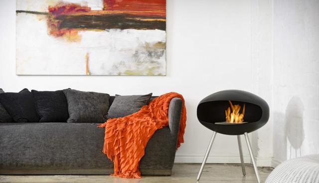 Mueble tapizado en chenille gris. La chimenea es de acero cromado, de la marca australiana Cocoon Fires. (Foto: Cocoon Fires)