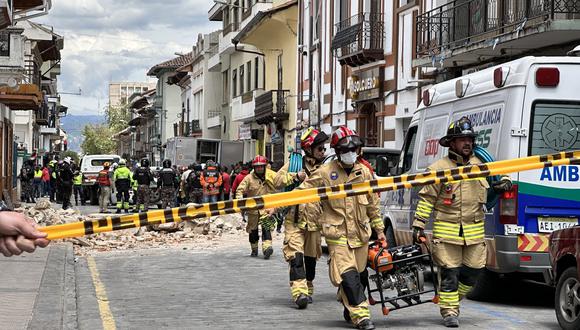 Miembros de los bomberos ayudan con los daños ocasionados por el sismo de magnitud 6,5 en la escala abierta de Richter, en la ciudad de Cuenca (Ecuador).